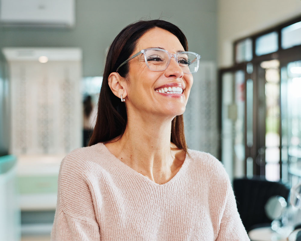 A client smiles while trying on eyewear