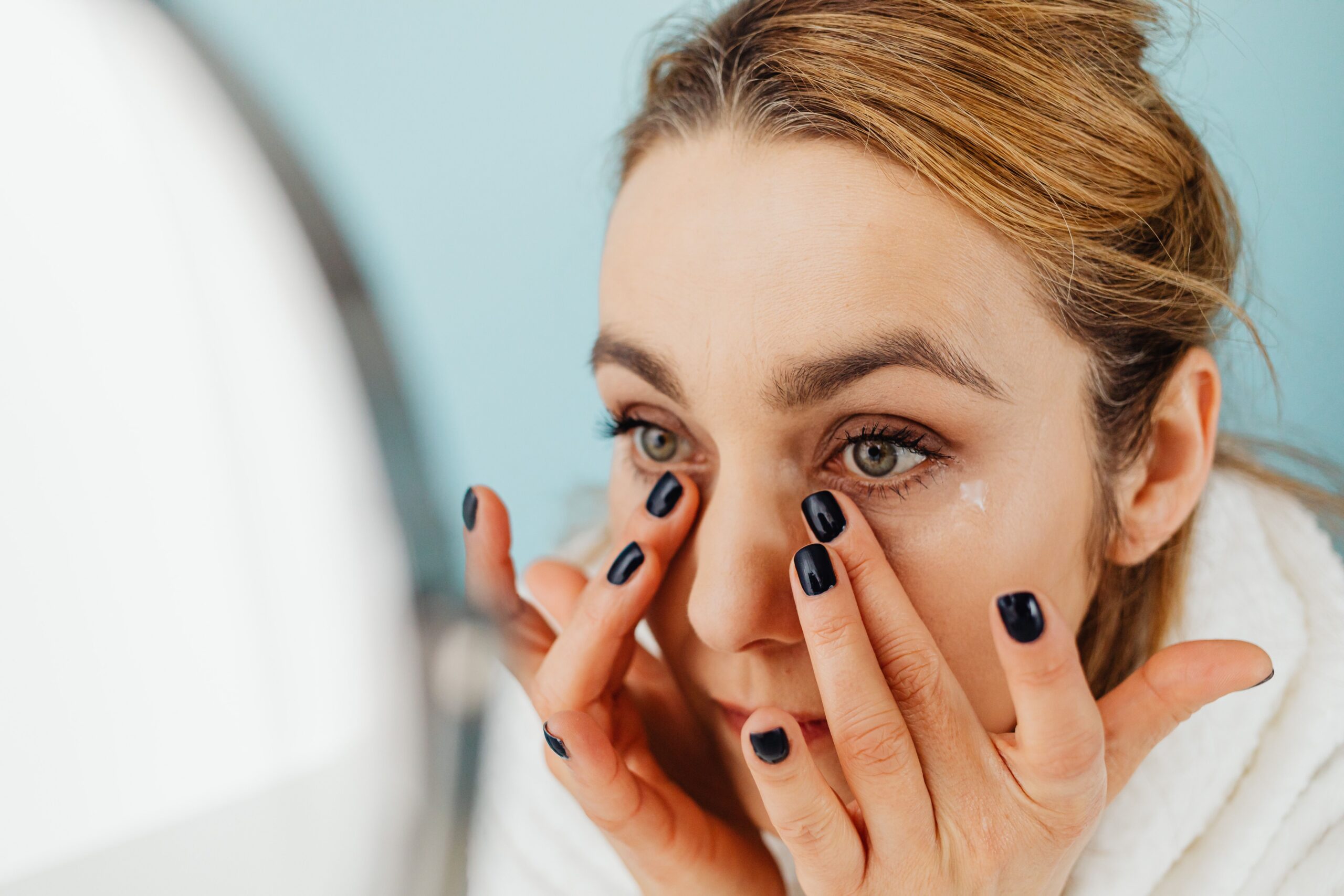 woman applying eyelid lotion